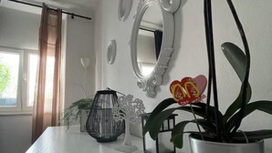 A room with a white table, a potted plant, a mirror, and decorative items. - Apartments Mavi - Two-Bedroom Apartment with Terrace and City View (Dubrovnik)