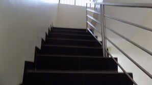 Eine Treppe mit Metallgeländern, die zu einem Fenster mit Jalousien führt.