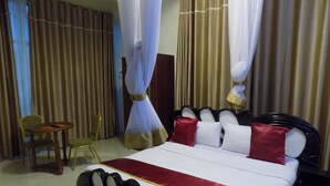 Ein Hotelzimmer mit einem Bett, einem Sessel und Vorhängen.