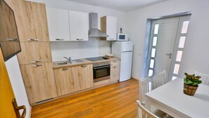 Una cocina moderna con armarios de madera, horno empotrado y microondas.