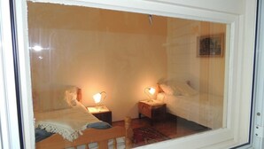 Une chambre avec deux lits, chacun étant muni d’une table de chevet et d’une lampe.