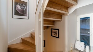 Una escalera con escalones de madera y un cuadro en la pared.