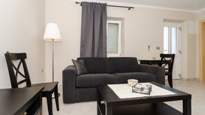 En moderne stue med en grå sofa, et sofabord og en lampe.