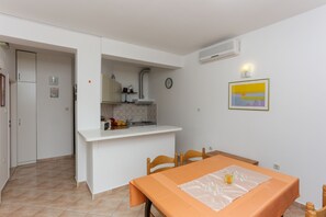 Eine kleine Küche mit weißer Arbeitsplatte, einem Spülbecken und einer Uhr an der Wand.