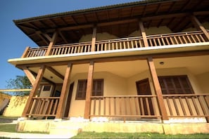 A two-story building with a balcony, wooden railings, and a tiled roof. - Pousada Nusa Dua Maresias (São Sebastião)