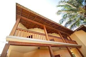 A two-story building with a balcony on the upper floor. - Pousada Nusa Dua Maresias (São Sebastião)