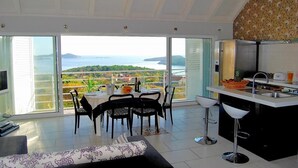 Ein geräumiger Wohnbereich mit einem großen Schiebeglastür, die auf einen Balkon mit Meerblick führt.