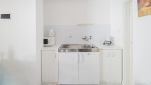 A small kitchenette with a microwave, coffee maker, and sink. - Apartments Veve - Studio Apartment with Terrace Sea View (Postira)