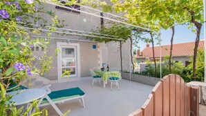A patio with a table and chairs, a bench, and a wooden gate. - Apartments Veve - Studio Apartment with Terrace Sea View (Postira)