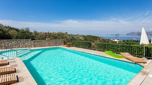A swimming pool with lounge chairs and a view of the sea. - Villa Bell Memories- Two Bedroom Apartment with Balcony and Sea View (Cavtat)