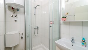 Une salle de bain moderne avec une douche à parois de verre, un lavabo blanc et des toilettes.
