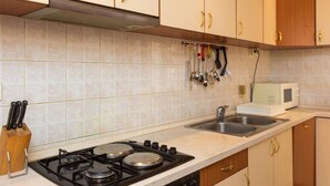 Una cucina con piano cottura a gas, due lavelli e un forno a microonde.