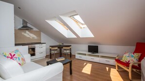 Moderni loft-tyylinen huoneisto, jossa on keittiö, ruokailutila ja oleskelualue.
