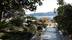 Un sendero de piedra que lleva a un mirador con vistas al mar y colinas.