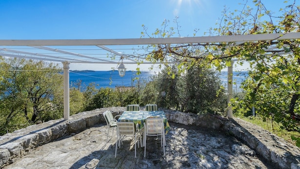 An outdoor patio with a table and chairs, a pergola, and a view of the sea. - Villa Soline - Two Bedroom Apartment with Terrace and Sea View (Mlini)