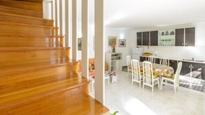 A staircase leading to a dining area with a table and chairs, a kitchen with cabinets, and a small seating area with a sofa and a side table. - Villa Soline - Two Bedroom Apartment with Terrace and Sea View (Mlini)