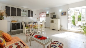 A bright, well-lit living area with a dining table, chairs, a sofa, and a TV. - Villa Soline - Two Bedroom Apartment with Terrace and Sea View (Mlini)