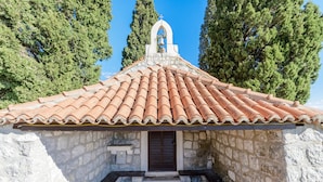 A stone building with a tiled roof and a bell tower. - Villa Soline - Two Bedroom Apartment with Terrace and Sea View (Mlini)