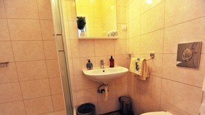 Ein Badezimmer mit Waschbecken, Spiegel, Handtuchhalter und Toilette.