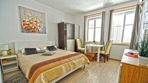 Ein ordentlich eingerichtetes Schlafzimmer mit Bett, Nachttischen, Schreibtisch und Stuhl.