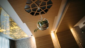 A modern interior with a geometric ceiling design, a hanging spherical ornament with greenery, and patterned wall textures. - Rooms Lejletul  - Superior Double Room with Square View (Kadr) (Split)