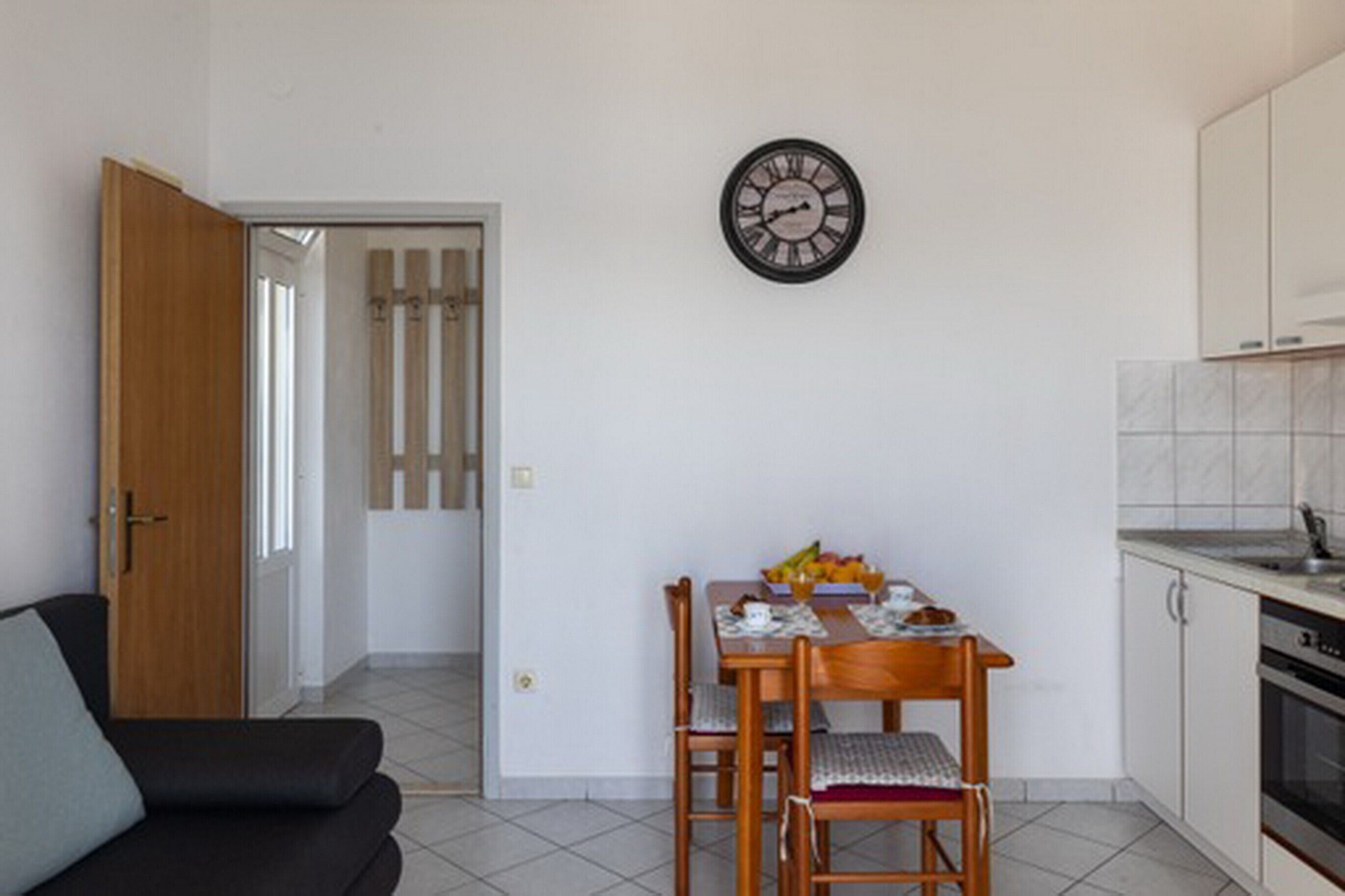 A compact living space with a dining area, a kitchen, and a sofa.