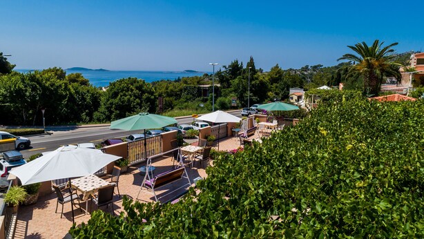Un espace extérieur aménagé avec des parasols, des tables et des chaises, situé en bord de mer et offrant une vue sur l’océan.