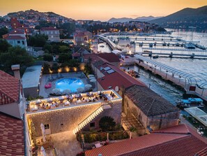 Ein Hotel am Wasser mit Schwimmbad, Außenbereich und Blick auf den Hafen.