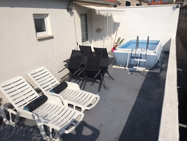 Un espace aménagé au bord de la piscine, avec des chaises longues et une petite piscine.