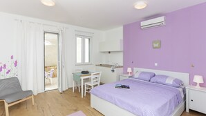 A bedroom with a bed, a desk, a chair, and a window. - Apartments Villa Karmen - Studio with Terrace (Lavanda) (Dubrovnik)