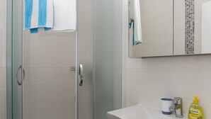 A modern bathroom with a glass-enclosed shower, a white sink, and a mirror above the sink. - Apartments Villa Karmen - Studio with Terrace (Lavanda) (Dubrovnik)