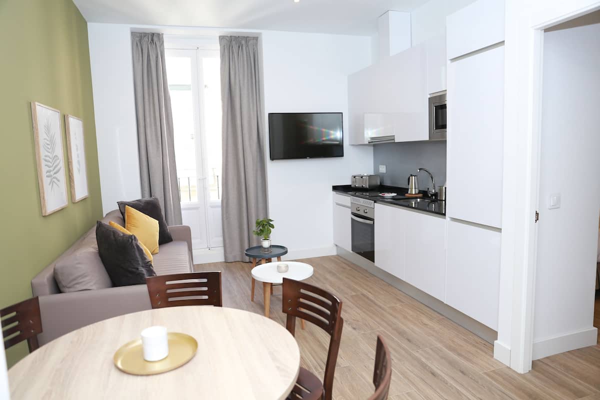 Un appartement moderne comprenant un coin repas, une cuisine et un espace de vie.