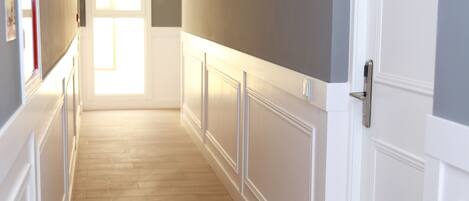 A hallway with wooden flooring, white walls, and a door marked with the number 4C.