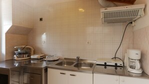 A kitchen with two stainless steel sinks, a coffee maker, and a built-in range hood.