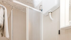 A bathroom with a toilet, a sink, and a shower stall.