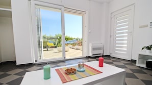 A modern kitchen with a white countertop, a bowl of nuts, a colorful mug, and a red candle. - Apartments Gusti - One Bedroom Apartment with Terrace and Sea View (Drace)