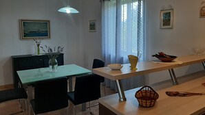 A dining area with a table, chairs, a vase with flowers, a bowl, and a basket. - Apartment Bruna - Two Bedroom Apartment with Terrace (Mirca)