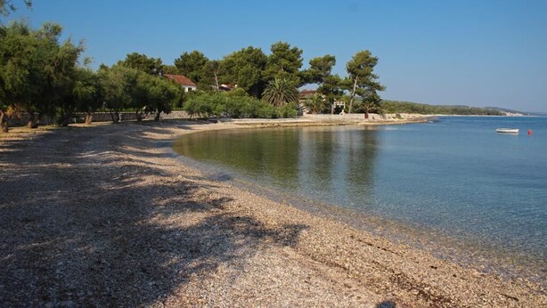 A pebbled beach with trees and a clear blue sky. - Apartment Bruna - Two Bedroom Apartment with Terrace (Mirca)