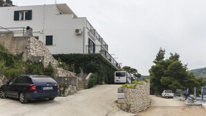 A building with a stone facade, a white exterior, and a balcony. - Apartments Posta - Studio with Balcony and Sea View (Saplunara)
