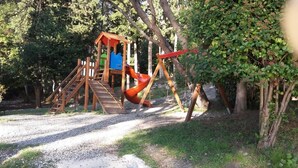 Un parque infantil con un tobogán de madera y una estructura para escalar.