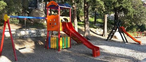 A playground with a slide and climbing structures.
