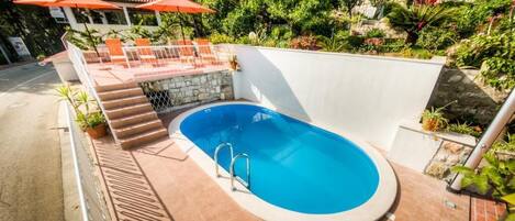 Una piscina al aire libre, tumbonas
