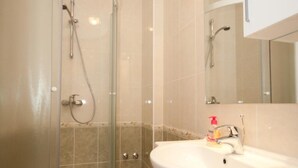 A modern bathroom with a glass-enclosed shower, a white sink, and a mirror above it. - Apartments Briest - Studio Apartment with Balcony (Dubrovnik)