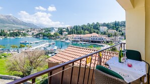 A balcony with a table, chairs, and a view of a marina and buildings. - Apartments & Rooms Mihajica- Comfort Studio Apartment with Balcony and Sea View (Cavtat)
