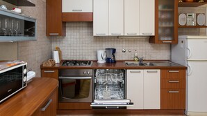 Una cocina moderna con armarios de madera, lavavajillas, estufa y microondas.