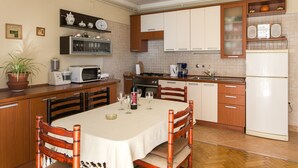 Una cocina con armarios de madera, microondas, estufa y refrigerador.