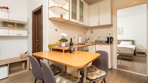 A compact kitchen with a wooden table, two chairs, and a small dining area.