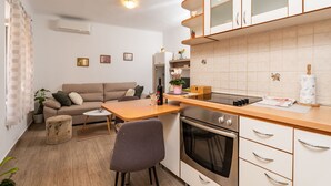 A compact kitchen with a dining area, a sofa, and a small table.