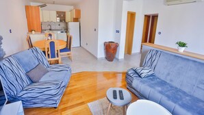 Una sala de estar moderna con un sofá, una mesa de centro y una zona de comedor con mesa y sillas.