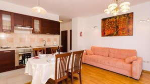 Un espacio habitable pequeño con cocina, comedor y sofá.